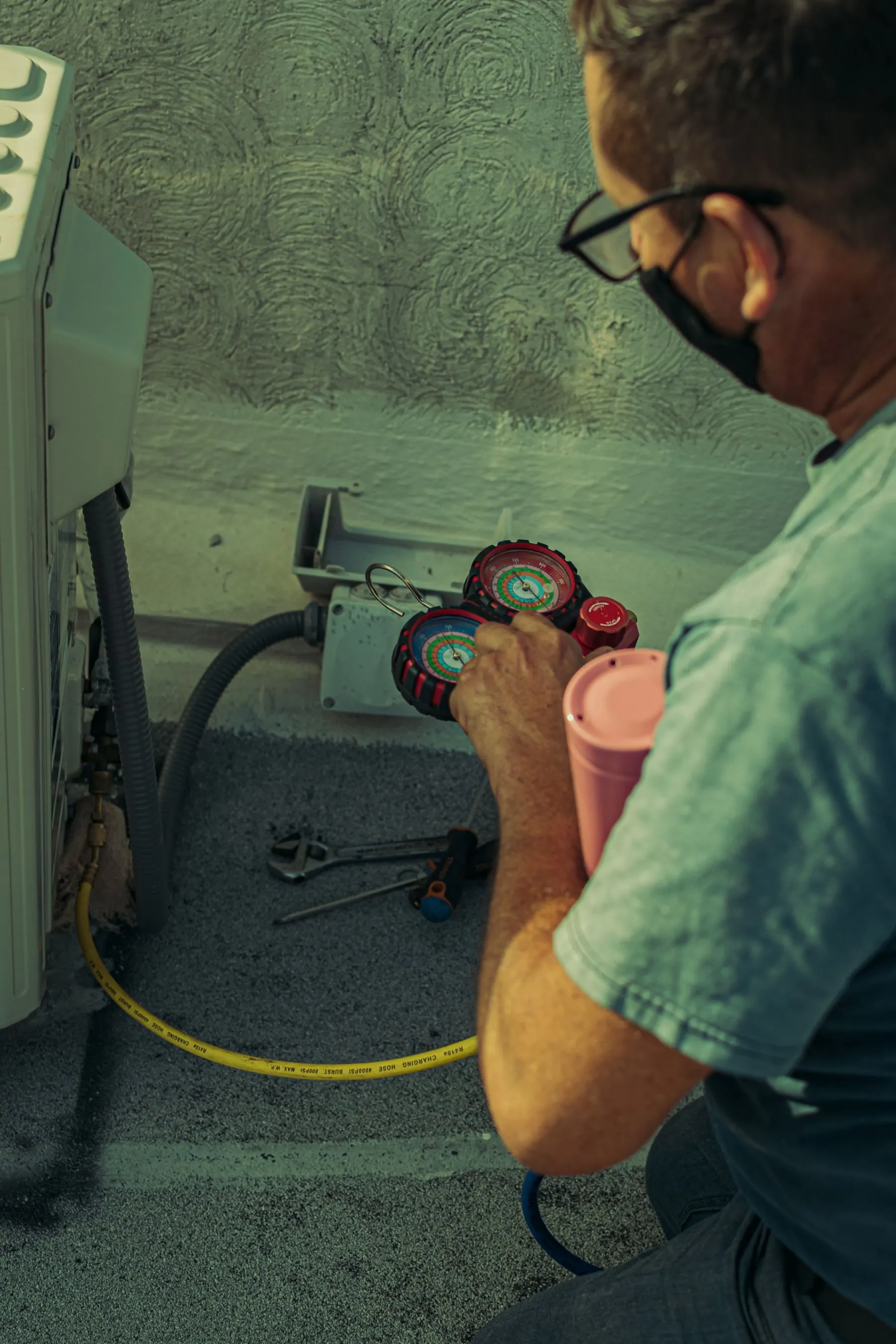 Technician checking refrigerant pressure with professional gauges
