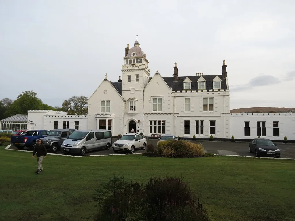 Country house inn glowing with warm light at dusk