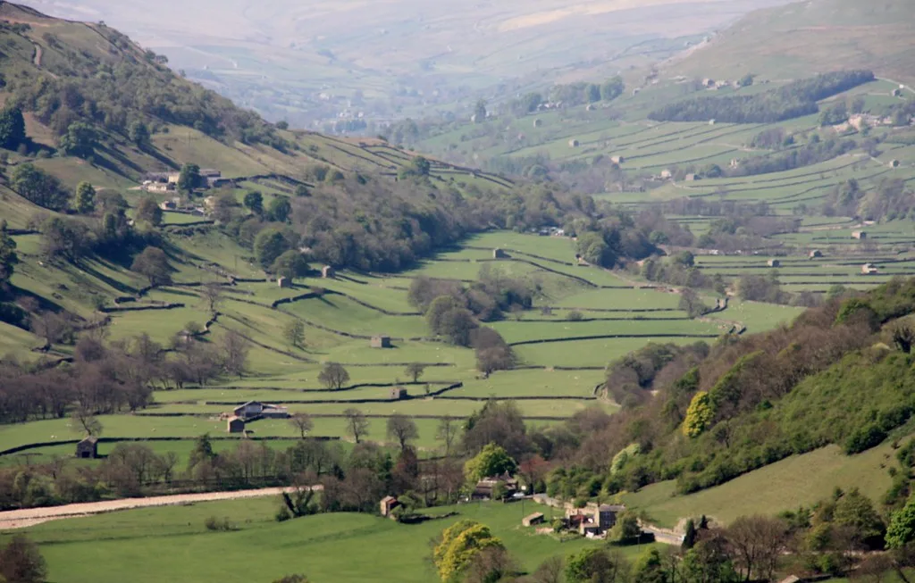 Green valley with dry stone walls under a blue sky