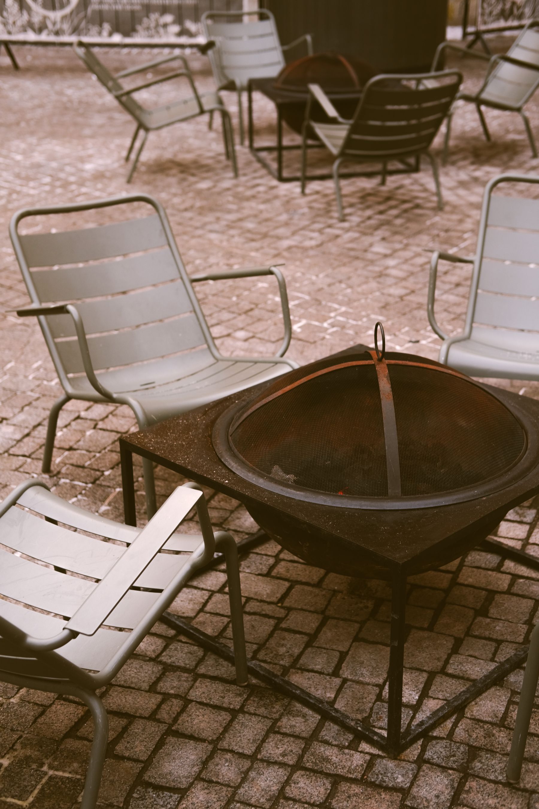 Patio fire bowl surrounded by simple outdoor chairs