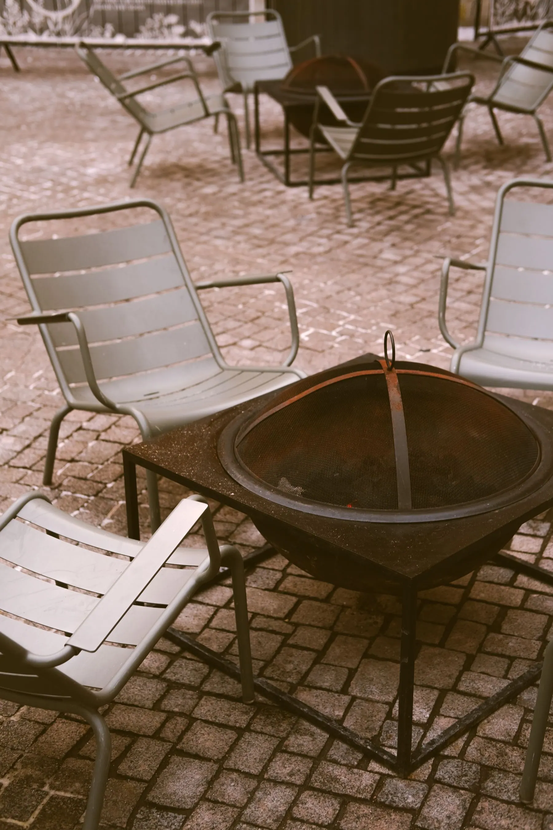 Patio fire bowl surrounded by simple outdoor chairs